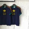 Luxuriöse Adidas Kurzarm-Kollektion aus marineblauer Seide mit Logo